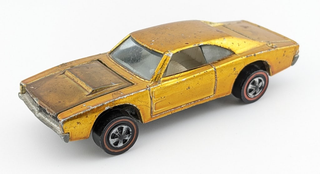 Hot Wheels Redline Gold Custom Dodge Charger: Hot Wheels Redline gold Custom Dodge Charger with white interior. The car has some chips, rub marks, roughness to the paint on the front passenger side fender, and wear from age.