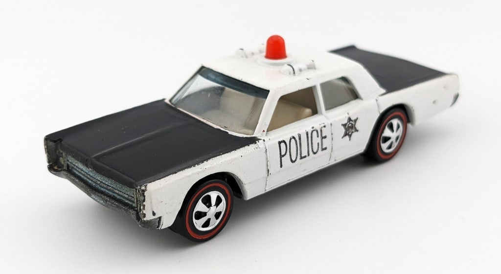 Hot Wheels Redline Police Cruiser w/ Opaque Siren: Hot Wheels Redline Police Cruiser with opaque red siren. The car has some fading to the decals, high edge wear, and a couple micro chips. The base has the initials "CH" written in sharpie.