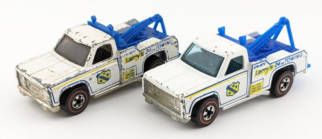 Hot Wheels Redline Flying Colors Ramblin Wrecker: (2) Hot Wheels Redline Flying Colors Ramblin Wreckers. Both are the variation with the phone number. The one has heavy paint loss and discoloration. The other has some scattered chips and edge wear.