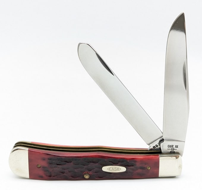1985 Case XX Jigged Red Bone Trapper R6254: 1985 Case XX Jigged Red Bone Trapper R6254. Knife is in nice polished condition with minimal wear on the blades, and scuffs on the bolsters from age and handling. Overall measures 4-1/4in when closed.