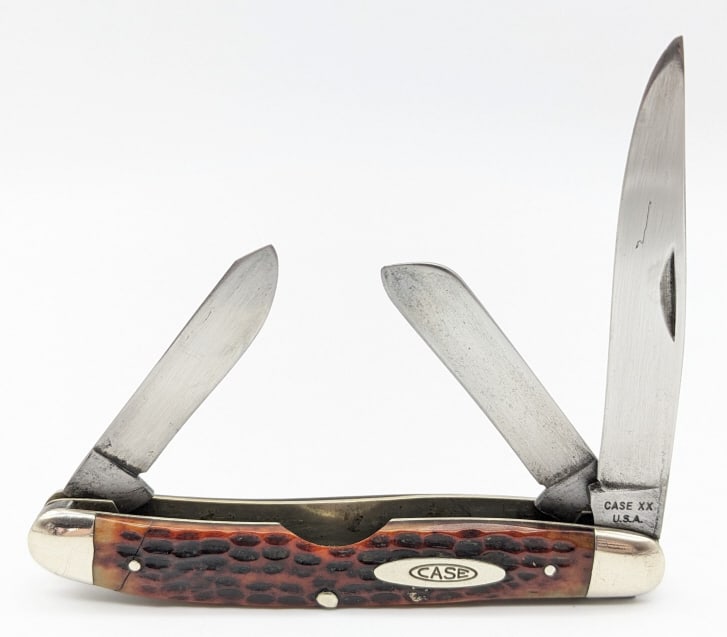 1965-69 Case XX Jig Bone Medium Stockman 63047: 1965-69 Case XX Jig Bone Medium Stockman 63047. Knife is in nice aged condition with wear on the blades, scuffs on the bolsters, and a through crack on the lower front handle scale. Overall measures 4