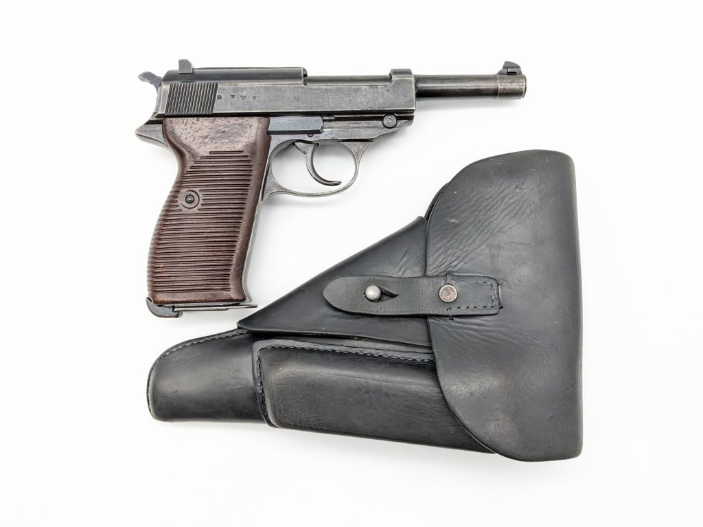 WWII German Spreewerk P.38 9mm Pistol w/ Holster: WWII German Spreewerk P.38 9mm Pistol w/ Holster. Comes in the original flap holster. Pistol is numbers matching and features a 4-7/8in barrel, worn blued finish, and brown bakelite grips. Pistol is i