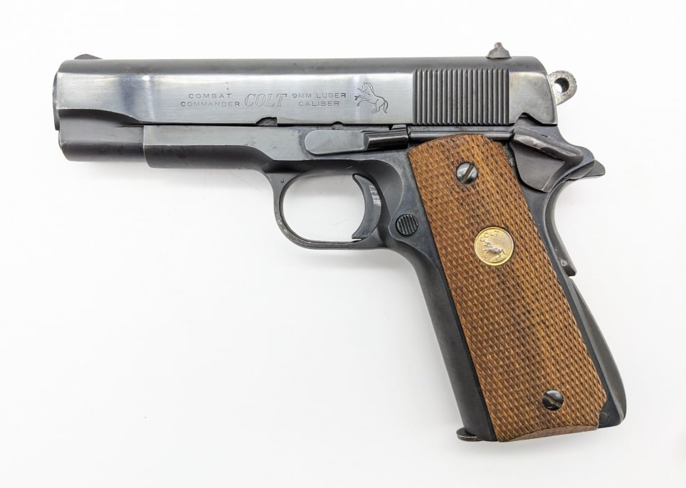 Colt Combat Commander 1911 9mm Semi Auto Pistol: Colt Combat Commander 1911 9mm Semi Auto Pistol. Features a 4-1/4in barrel, blued finish, and checkered wood grips. Pistol is in good used condition with scattered spots of finish wear and light wear 