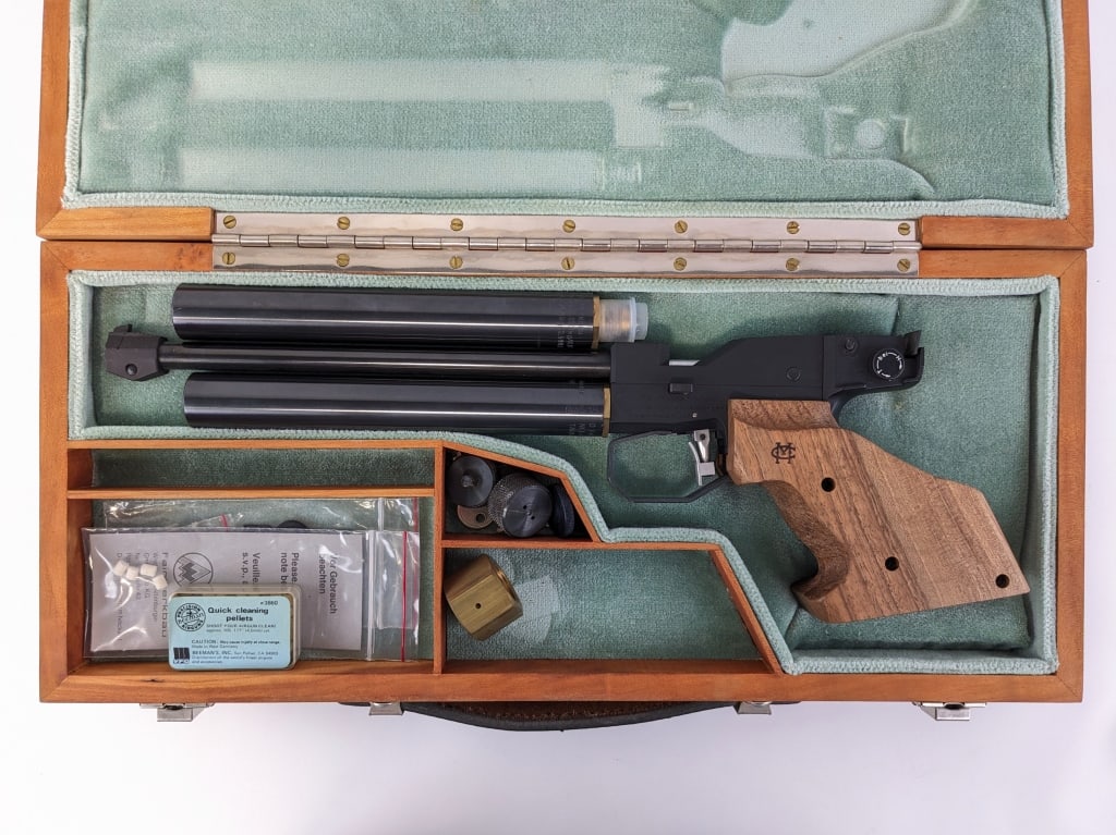 Feinwerkbau Model 2 .177 Cal Pellet Target Pistol: Feinwerkbau Model 2 .177 Cal Pellet Target Pistol. Comes in a wooden case with an extra reservoir and other attachments. Features a 10in barrel, adjustable rear sight, matte black finish, and wooden t