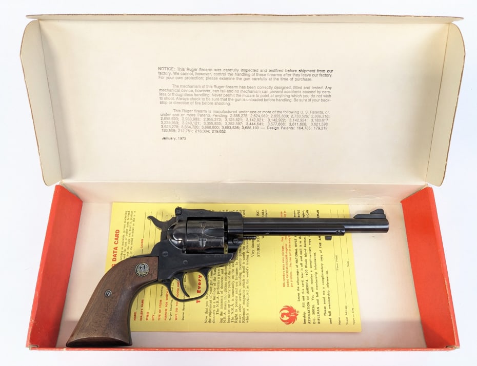 Ruger New Model Single Six .22 Cal Revolver w/ Box: Ruger New Model Single Six .22 Cal Revolver w/ Box. Features a 6-1/2in barrel, adjustable rear sight, blued finish, and wood grips. Pistol is in used condition with scattered finish wear across and he