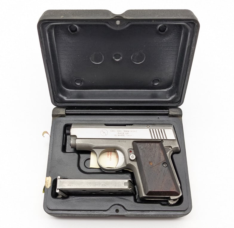 AMT Back Up .380 / 9mm Kurz Pistol w/ Case: AMT Back Up .380 / 9mm Kurz Semi Auto Pistol w/ Case. Features a 2-1/2in barrel, stainless steel finish, and hardwood grips. Pistol is in good used condition with some light scuffs and wear from use a