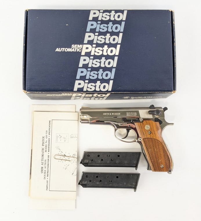 Smith & Wesson Model 439 9mm Pistol w/ Box: Smith & Wesson Model 439 9mm Pistol w/ Box. Comes in the original box with an extra magazine, cleaning kit, and paperwork. Features a 4in barrel, nickel finish, and checkered wood grips. Pistol is in