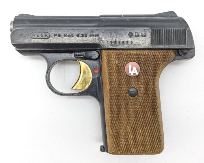 Reck Model P8 6.35mm / .25 ACP Semi Auto Pistol: Reck Model P8 6.35mm / .25 ACP Semi Auto Pistol. Features a 2-1/4in barrel, black finish, gold finish trigger, and checkered wood grips. Pistol is in used condition with some surface rusting, scuffs, 