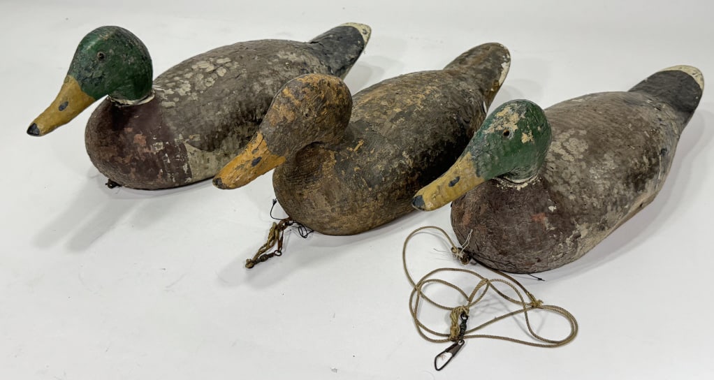 3) Early Wooden Duck Decoys w/ Glass Eyes: Lot of three early wooden duck decoys with glass eyes. Decoys are in worn codnition with paint loss, flaking paint, weathering, and other wear from use and age. One of the decoys is missing its glass 