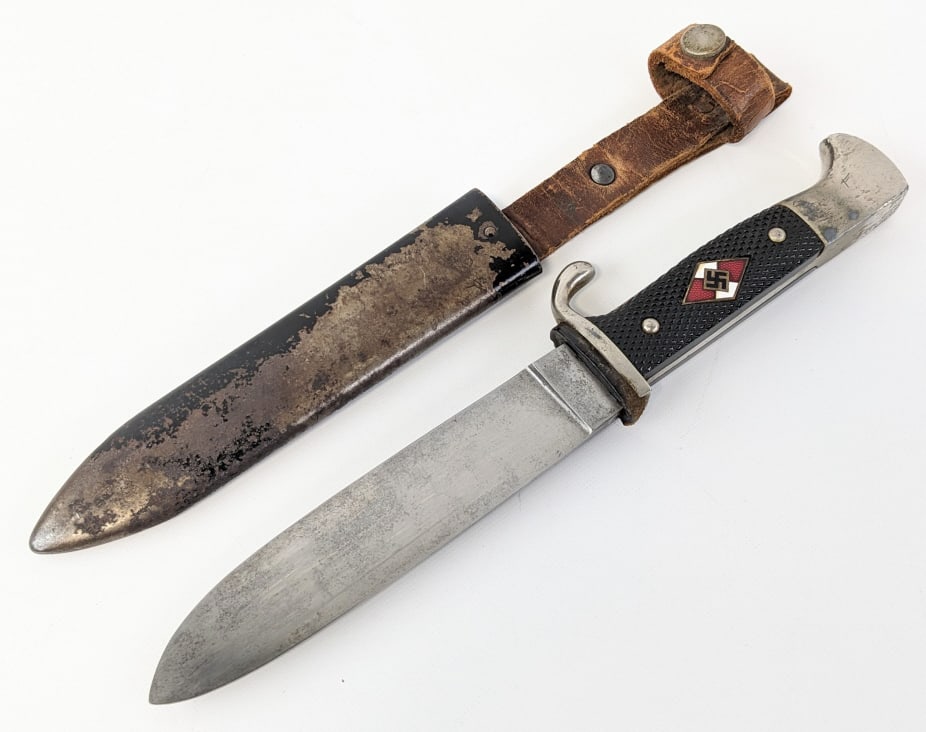 WWII German Hitler Youth Dagger w/ Scabbard: WWII German Hitler Youth Dagger w/ Scabbard. Dagger is made by Eickhorn and features a semi polished blade marked RZM M7/66, single downturned guard, checkered black plastic handle scales with Hitler