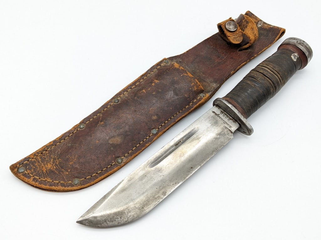 WWII Cattaraugus 225Q Fighting Knife w/ Sheath: WWII Cattaraugus 225Q Fighting Knife w/ Sheath. Features a fullered clip point bladde, single steel guard, stacked leather handle, and steel pommel. Knife is in nice aged condition with scratches on t