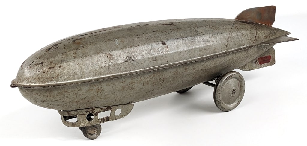 Keystone Mfg. Co. Graf Zeppelin: Keystone Mfg. Co. Graf Zeppelin pull toy. The zeppelin has some old overpaint and the top rear wing has been replaced. Still displays well with patina and a good look. Measures approximately 25" long.