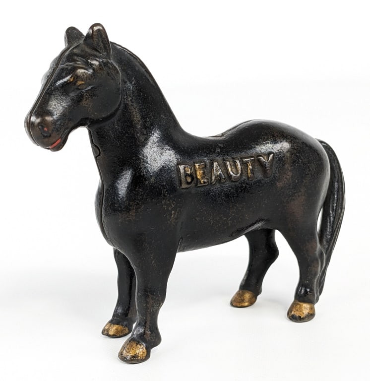 Arcade Cast Iron "Beauty" Horse Bank: Circa 1912 - Arcade cast iron "Beauty" horse bank. "Beauty" is embossed on the one side. Painted in black overall with gold hooves. Measures approximately 5" long. - From the Paul Link Collection