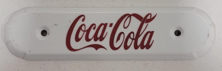 Vintage Coca-Cola Porcelain Plaque: Vintage Coca-Cola porcelain plaque. The plaque is in nice condition with no chips or cracks. Measures approximately 2-3/8" tall x 9-3/4" across.