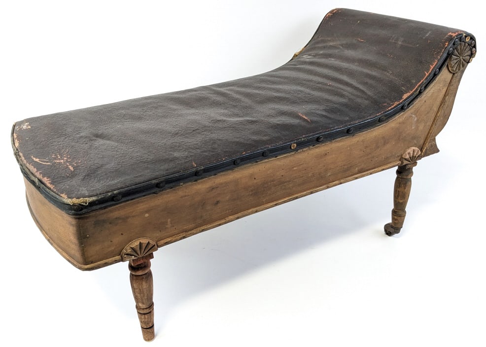 Antique Salesman's Sample Chaise Lounge: Antique Saleman's Sample chaise lounge. Has a wood body with leatherette upholstery, has age and display wear, missing one metal caster. Measures 14-1/2" tall x 28" across x 11-1/2" wide.