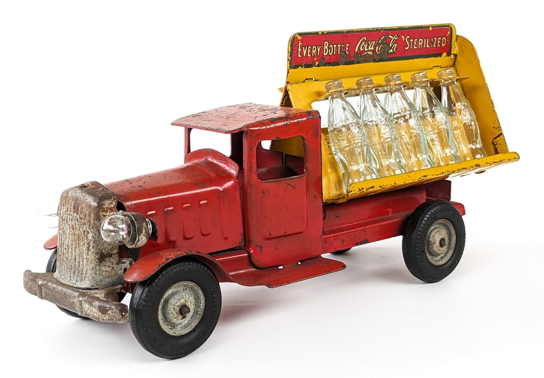 Metalcraft Coca-Cola Bottle Delivery Truck: Metalcraft Coca-Cola bottle delivery truck with electric headlights. The truck has decal loss, paint loss, and wear from play / age. The rear decal has been replaced. Measures approximately 11-1/2" lo