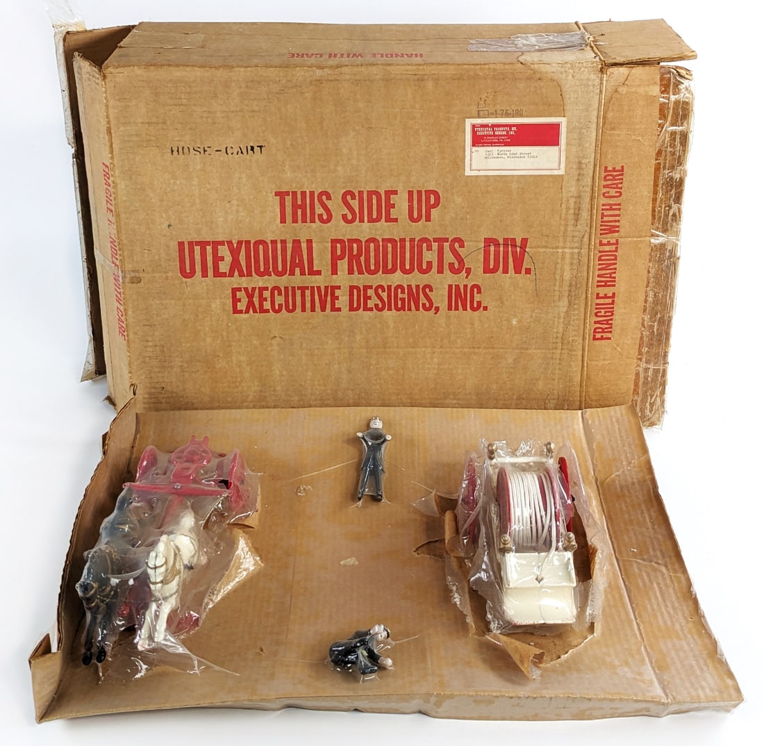 Contemporary Horse Drawn Hose Cart In Box: Contemporary cast iron horse drawn hose cart in the original box. The hose pumper is loose from the plastic. The box measure approximately 24" long by 20" wide by 9" tall.