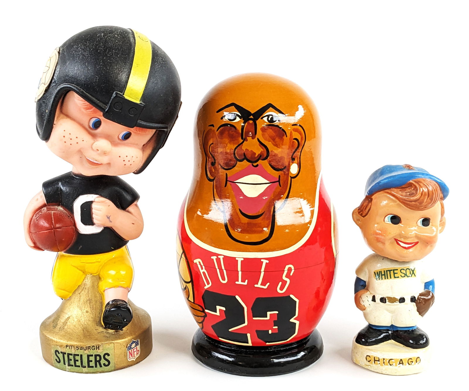 Vintage Pittsburgh Steelers Bobblehead, White Sox Bobblehead, & Chicago Bulls Nesting Dolls: Vintage Pittsburgh Steelers bobblehead, Chicago White Sox bobblehead, and Chicago Bulls Russian nesting dolls. All have some general wear from age, display, and handling. The Pittsburgh bobblehead mea