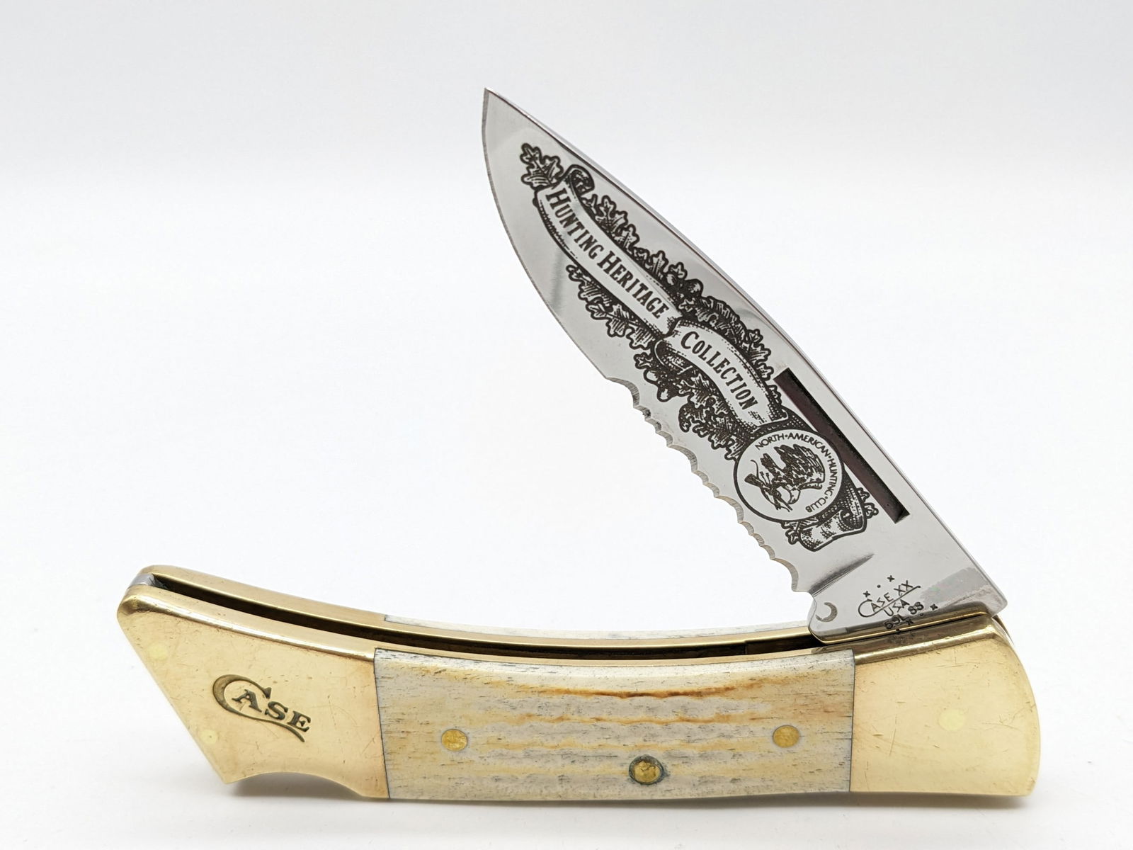 2002 Case XX NAHC Hunting Herritage Collection Natural Bone Lock Back Knife 6159L: Knife features a half sawtooth blade with North American Hunting Club etching. Knife is in nice condition with some heavy dings and scuffs on the brass bolsters. Overall measures 4-7/8in when closed.