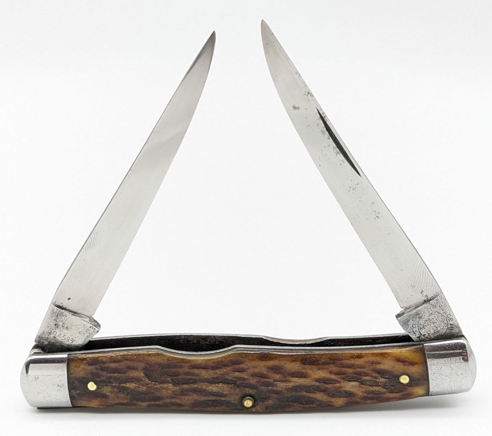 Vtg Remington R4593 Jig Bone Muskrat Knife: Knife is in good used condition with polished blades with material loss, polished bolsters with some scuffs and dings, and jig bone handle scales. Overall measures 4in when closed.