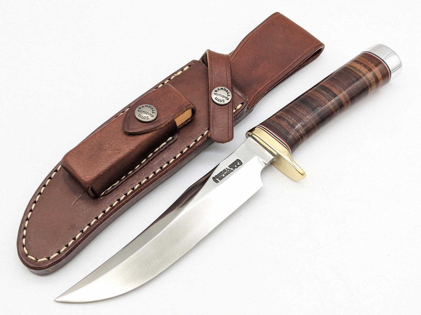 Randall Model 12 6in Little Bear Bowie w/ Sheath: Knife is in like new condition. Features a thumb notched blade, brass single downturned guard, stacked leather handle, duralumin butt cap, and nut pommel. Comes with the Randall leather sheath and the