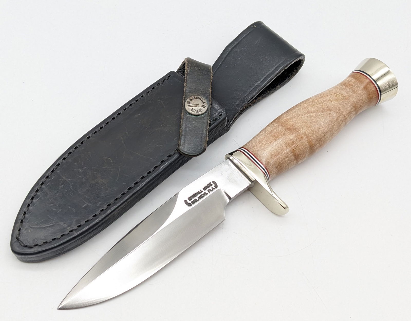 Randall Stabilized Maple Combat Companion w/ Sheath: Knife is in very nice condition with some light carbon spots on the blade, and scuffs on the sheath from handling. Features a nickel silver single downturned guard, stabilized maple handle, and nickel