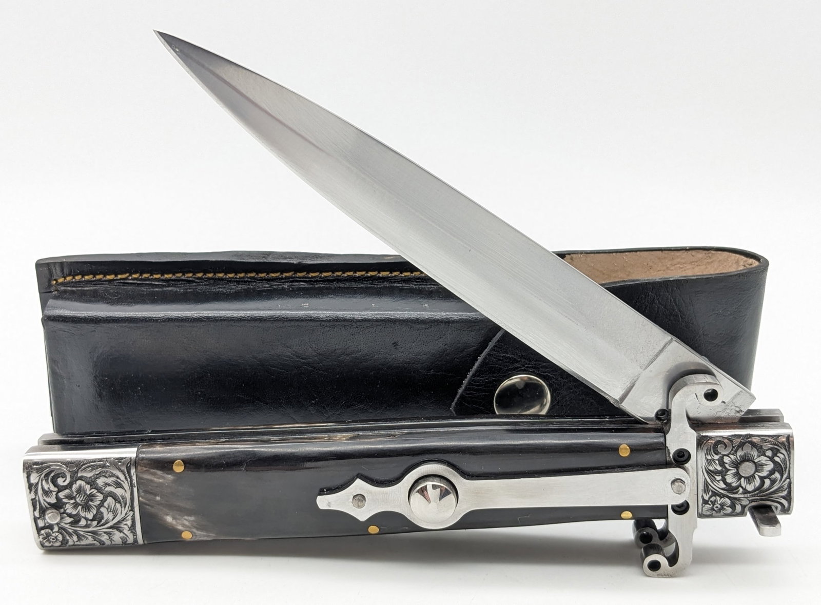 Large Engraved Buffalo Horn Stiletto Switchblade Knife w/ Sheath: Knife is in like new condition with file work along the spine. Overall measures 7in when closed.