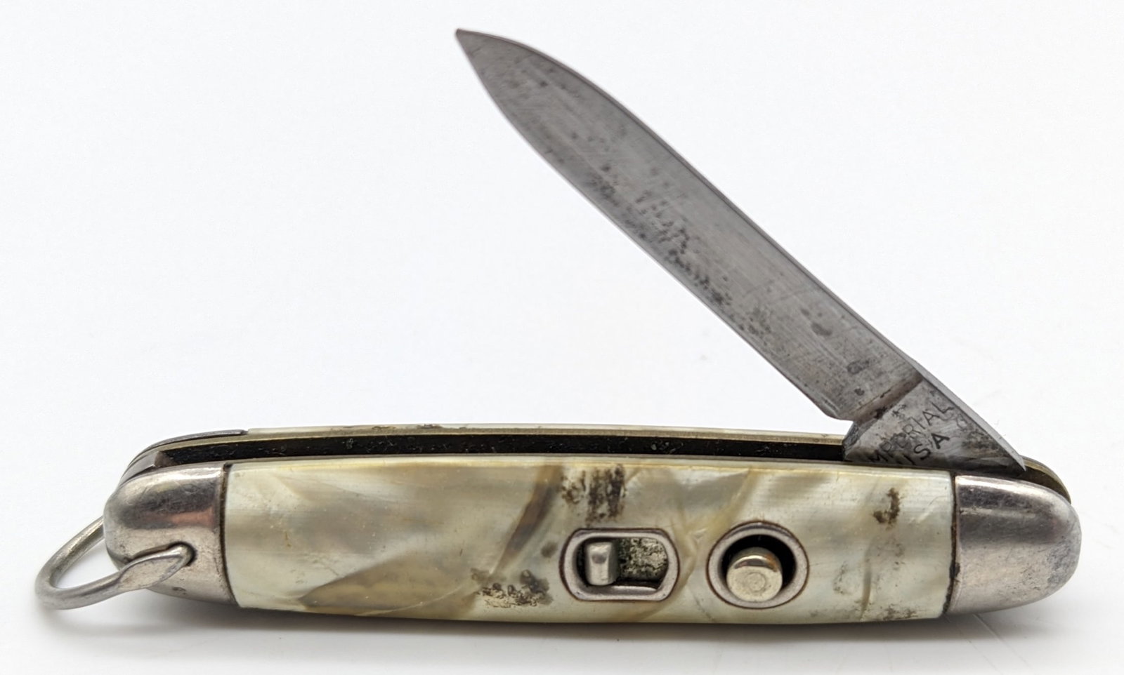 Imperial Mini Faux Pearl Switchblade Knife: Knife is in fair aged condition with scratches and carbon spotting on the blade, scuffs and tarnishing on the bolsters, and wear on the handle from use and handling. Knife spring is strong, and locks 