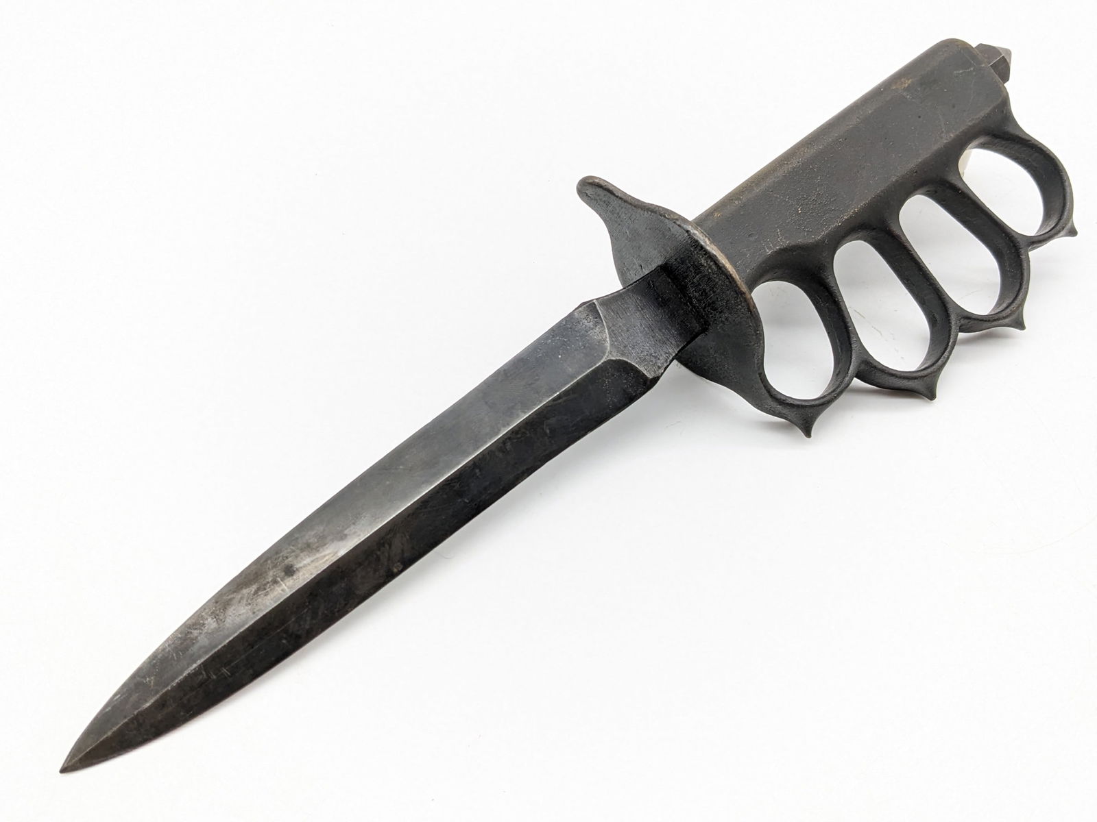 WWI L.F.&C. US 1918 Knuckle Duster Trench Knife: Knife features its original blacked finish with a double edged dagger blade, and cast brass knuckle duster handle with a skull crusher pommel. Knife is in very nice condition for the age with some tar