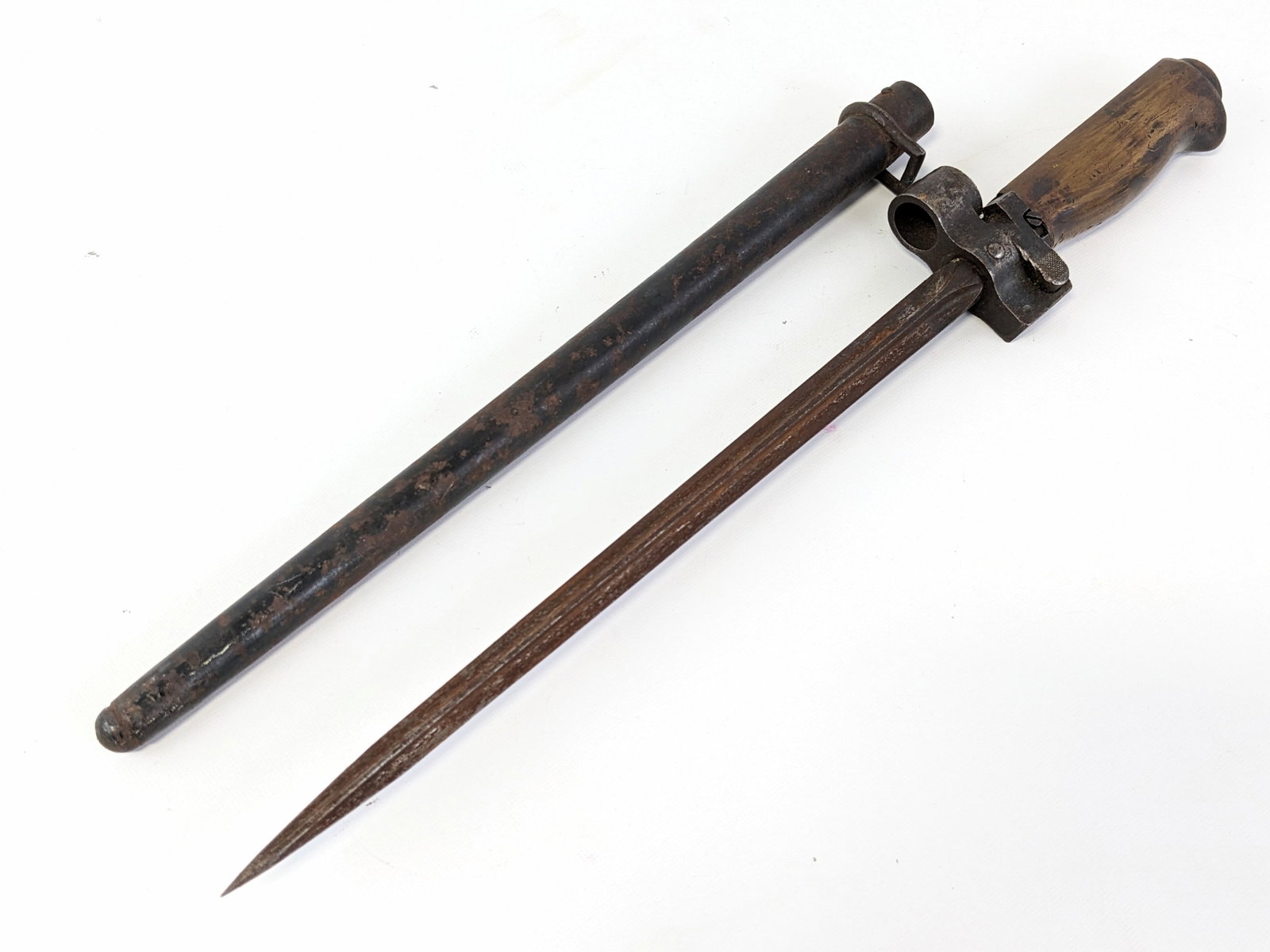French M1886 Infantry Lebel Bayonet w/ Scabbard: Features an epee style blade, lugged guard with serial number 87, and steel handle with a brass finish. Bayonet is in aged condition with surface rusting on the blade, and dings and scuffs on the guar