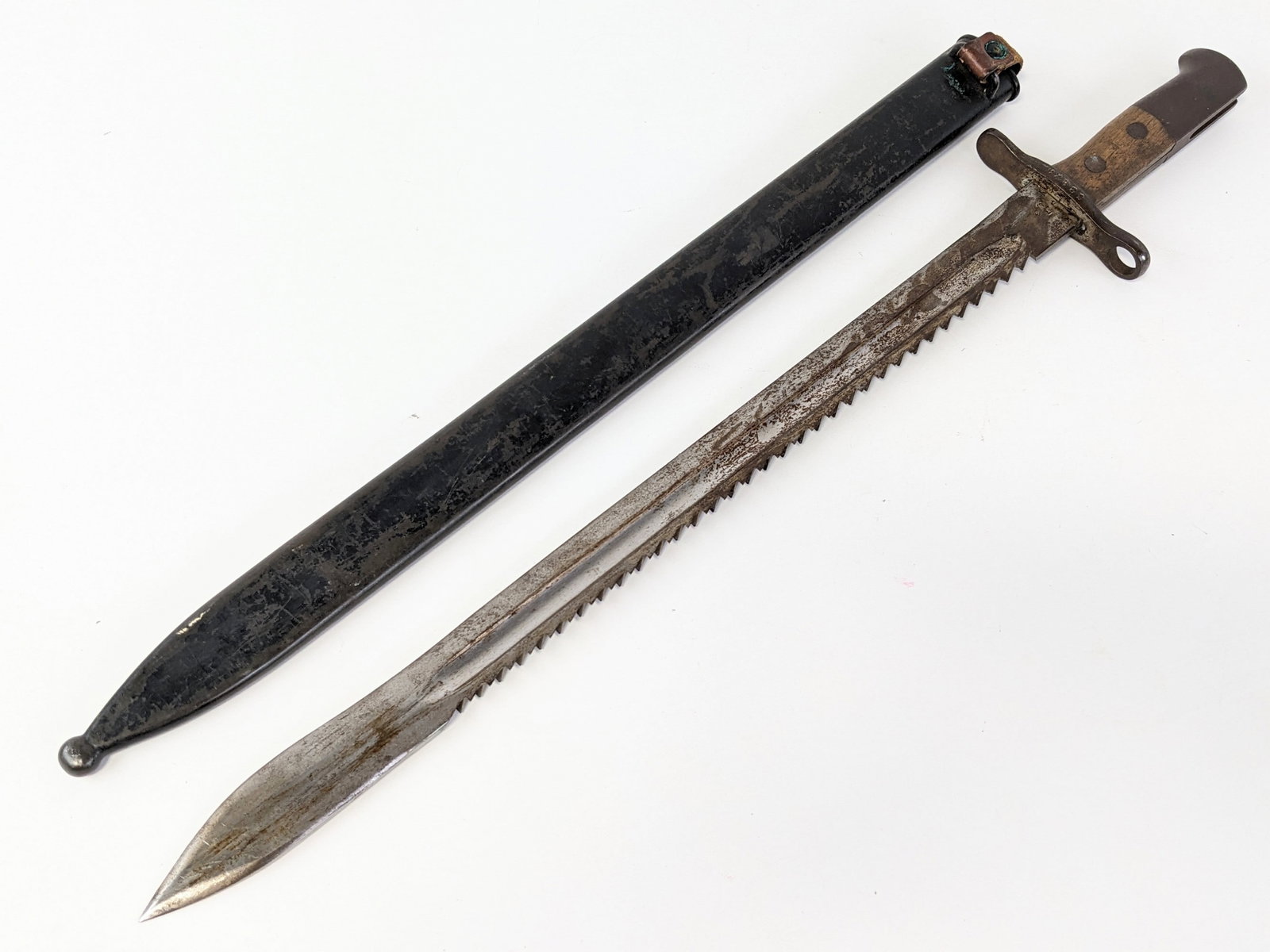 Swiss Model 1914 HS Pioneer Sawtooth Back Bayonet w/ Scabbard: Features a sawtooth spine blade stamped HS with an inspection mark on the tang, squared off steel guard, wood handle scales, and steel pommel. Bayonet is in fair condition with tarnishing and scuffs o