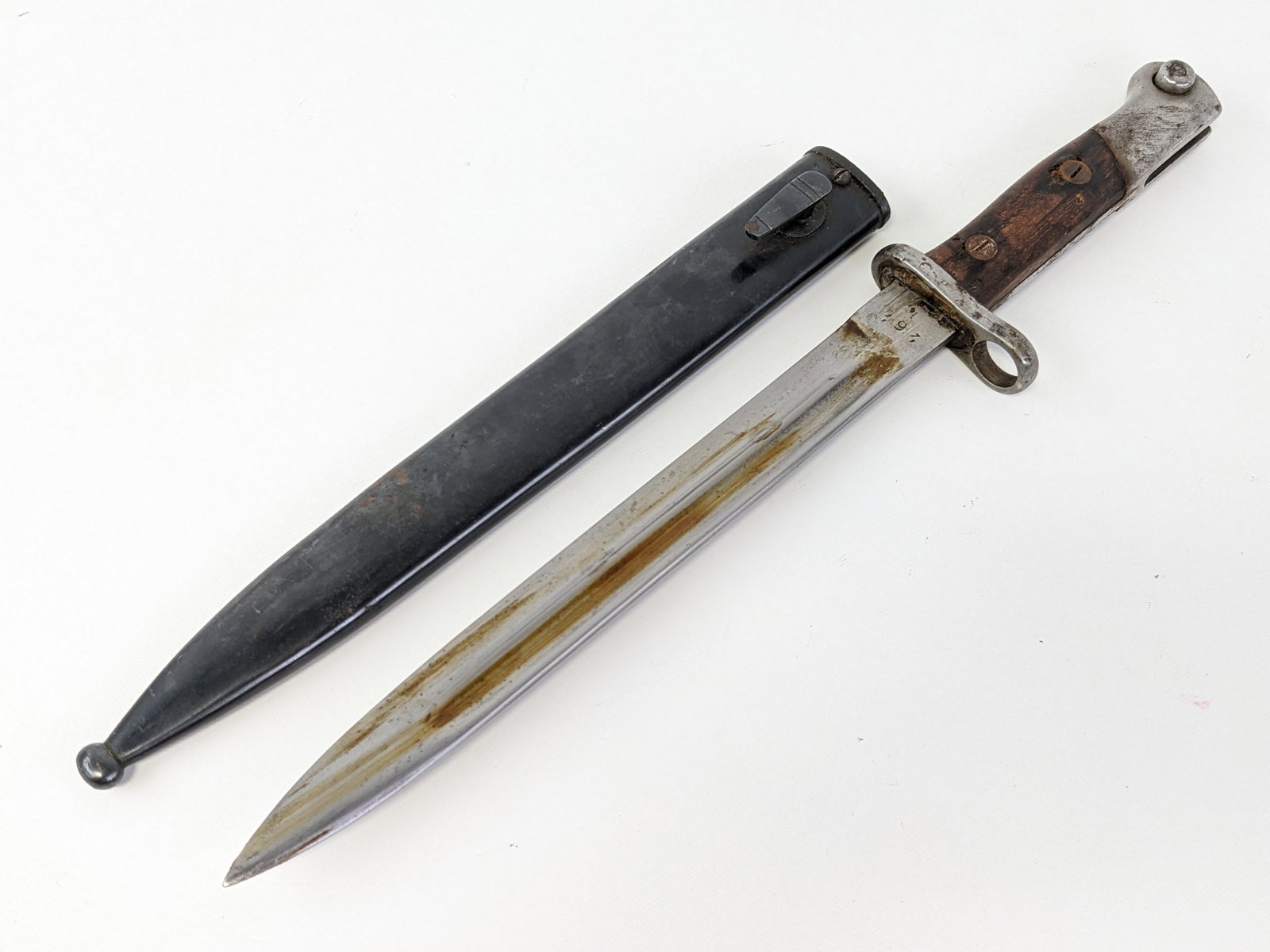 Spanish M1943 Mauser Bayonet w/ Scabbard: Bayonet is stamped with the serial number 262 and inspection mark H on the tang. Bayonet is in nice condition with tarnishing on the guard, and tarnishing and general wear on the handle and pommel. Bl