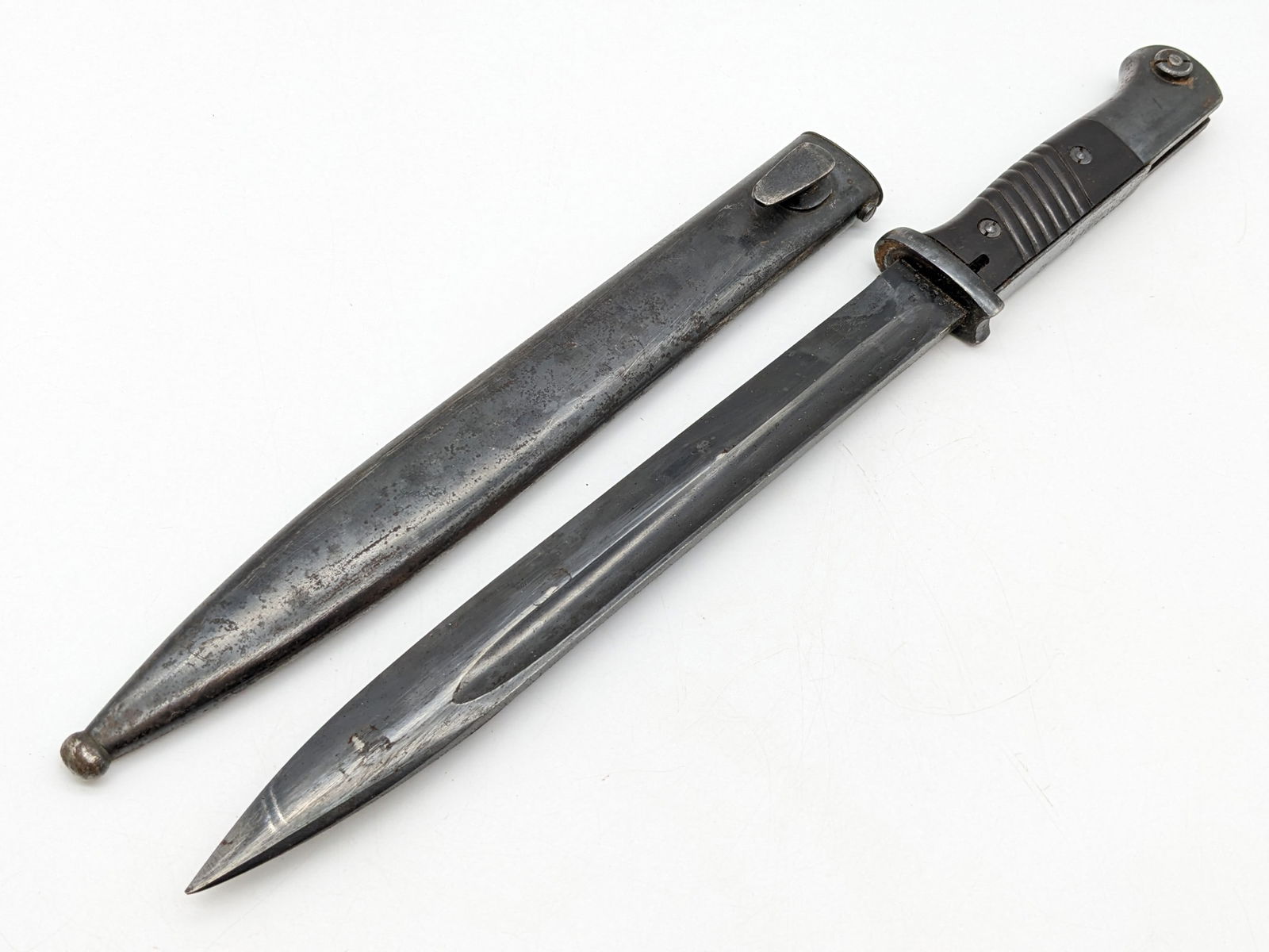WWII 1940 German Clemen & Jung K98 Mauer Bayonet w/ Matching Scabbard: Features a nice blackened finish blade stamped with the manufacturer and serial number 7273 b, bakelite handle scales, and Waffenamt stamps on the pommel. The scabbard is also marked with the manufact