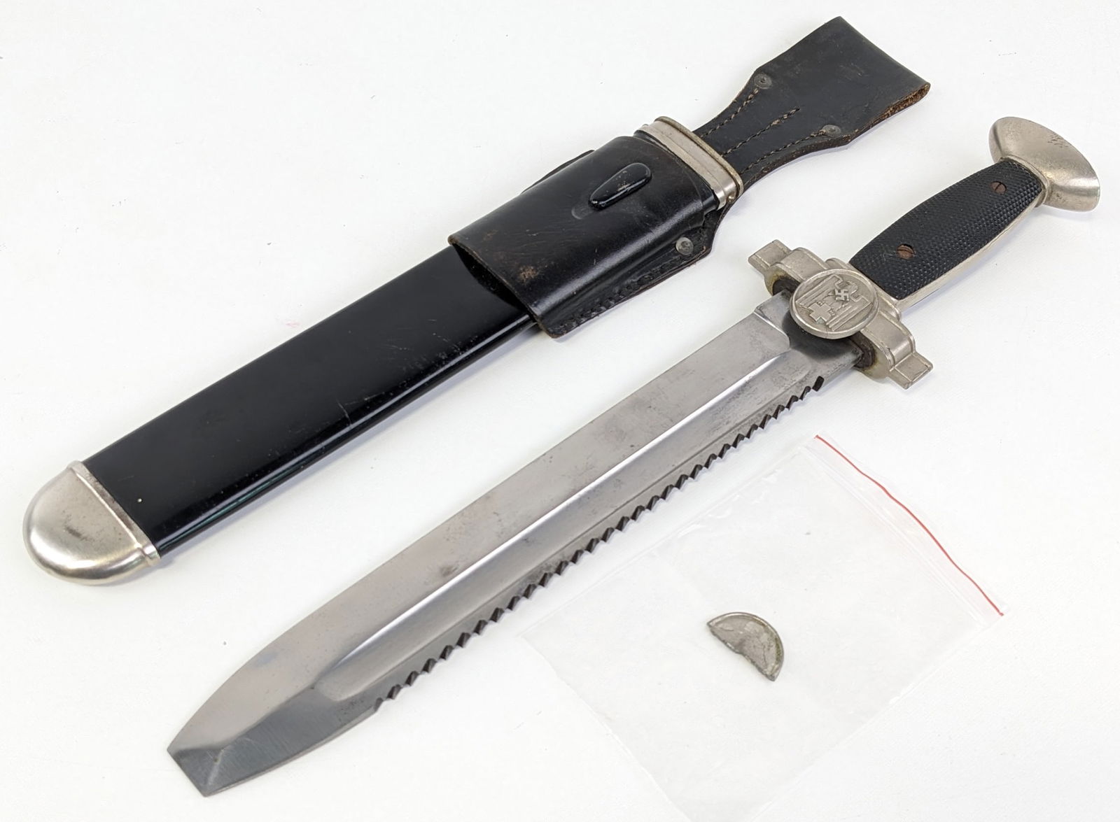 WWII German Red Cross Hewer Dagger w/ Scabbard & Frog: Features a flat tip sawtooth spine blade stamped Ges. Geschutz, cross guard with the German red cross eagle, black checkered handle on one side and smooth plastic on the other, and a crowned pommel. T