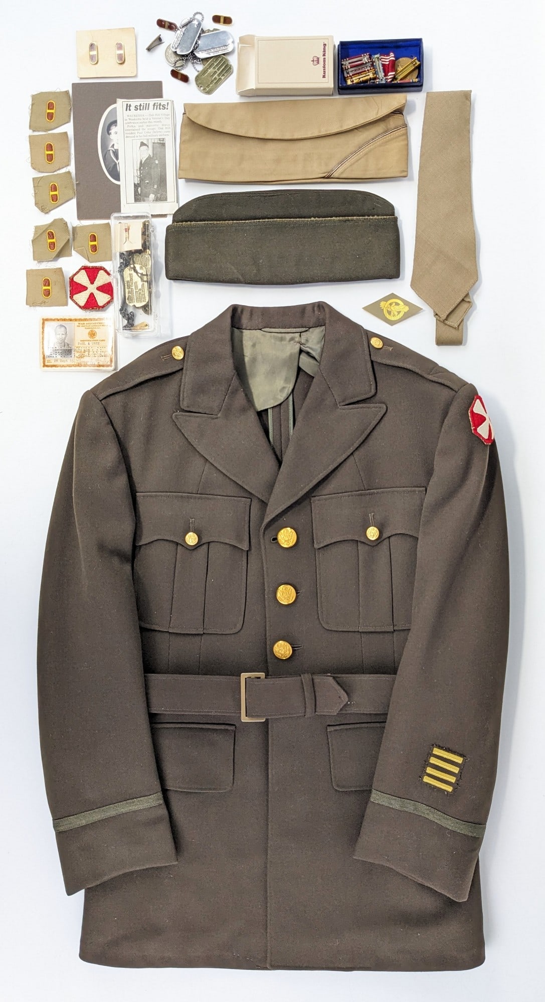 Named WWII US Army Jacket, Pins, & Identification: This group is from WWII veteran Paul Unke and includes the jacket, side cap, ID card, dog tags, pins and ribbons, and a news clipping of him in his uniform later in life. Pins include multiple sets of