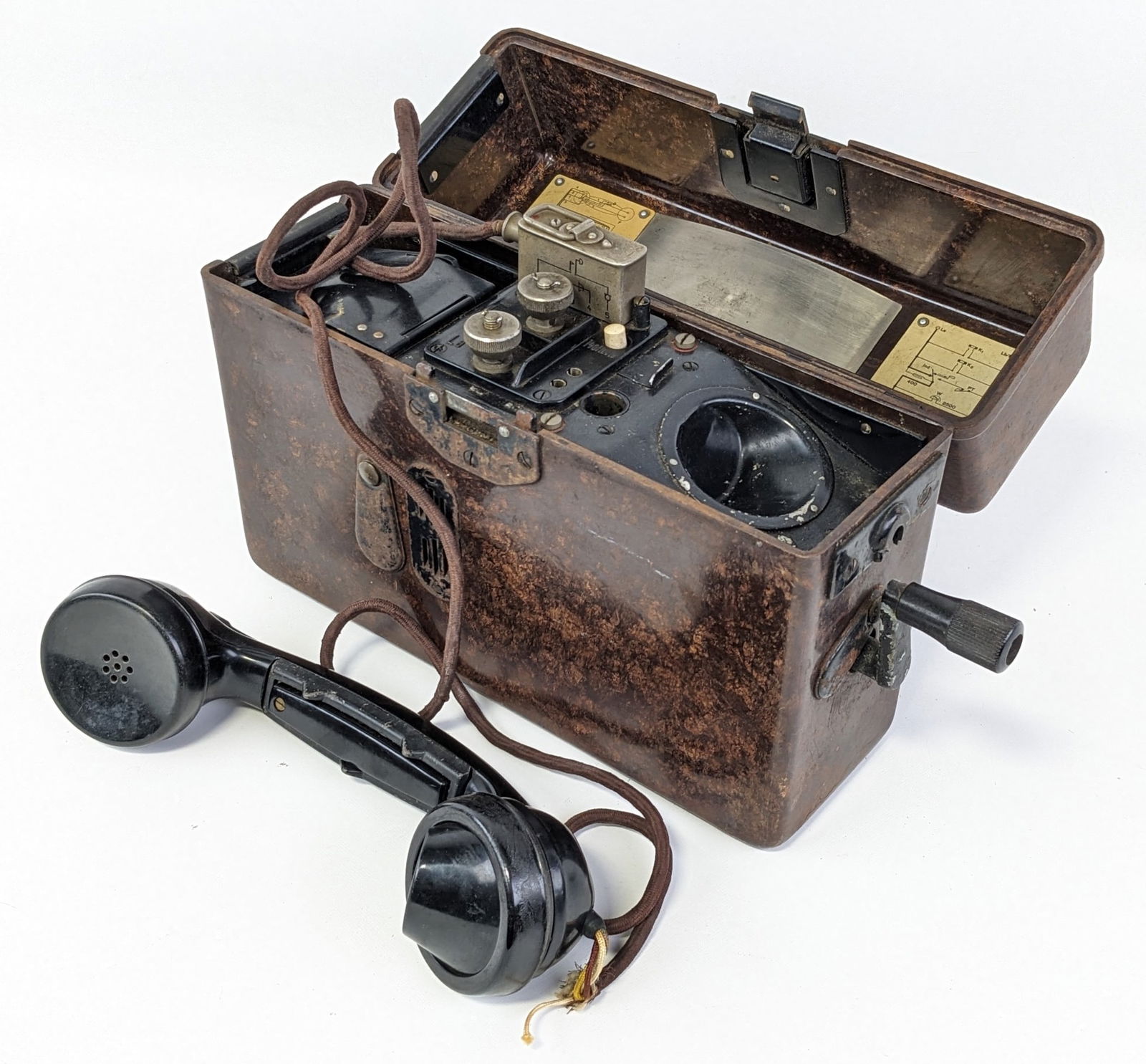 WWII German St & Co. Field Telephone: Phone is dated 1936 and comes in a bakelite case. Phone is in nice condition with light general wear on the hardware, some frayed wires, and scuffs on the case from use and handling.