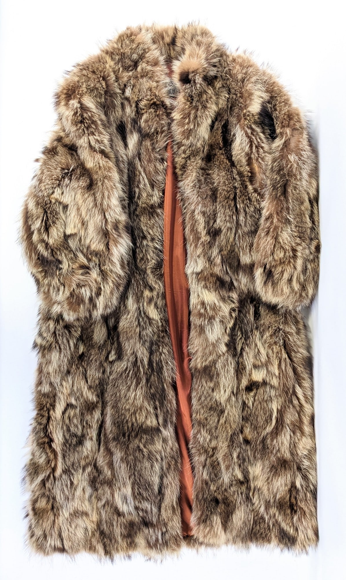 Raccoon Rump Fur Coat: This fur coat is in good condition with no rips, frays, or stains. It is a shin length coat made out of natural raccoon rump fur pieces with a brown smooth material on the inside. The lining is 100% a