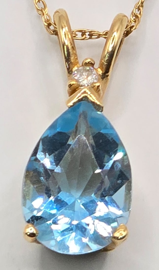 Ladies 14K Yellow Gold Blue Topaz & Diamond Pendant & Chain: Ladies 14K Yellow Gold Blue Topaz & Diamond Pendant & Chain. The pendant measures 3/4" tall and the chain measures 16" long. Total weight is 2.03 grams.