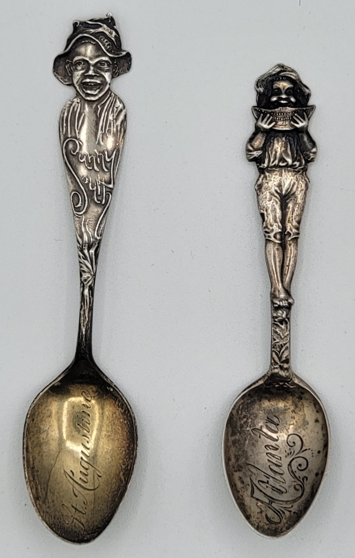 (2) Antique Black Americana Sterling Silver Souvenir Spoons: Spoons include a boy eating watermelon, bowl reads "Atlanta" and Sunny South, bowl reads "St. Augustine". They measure 3-5/8" to 4-1/8" long. Total weight .67 troy ounces of sterling silver.
