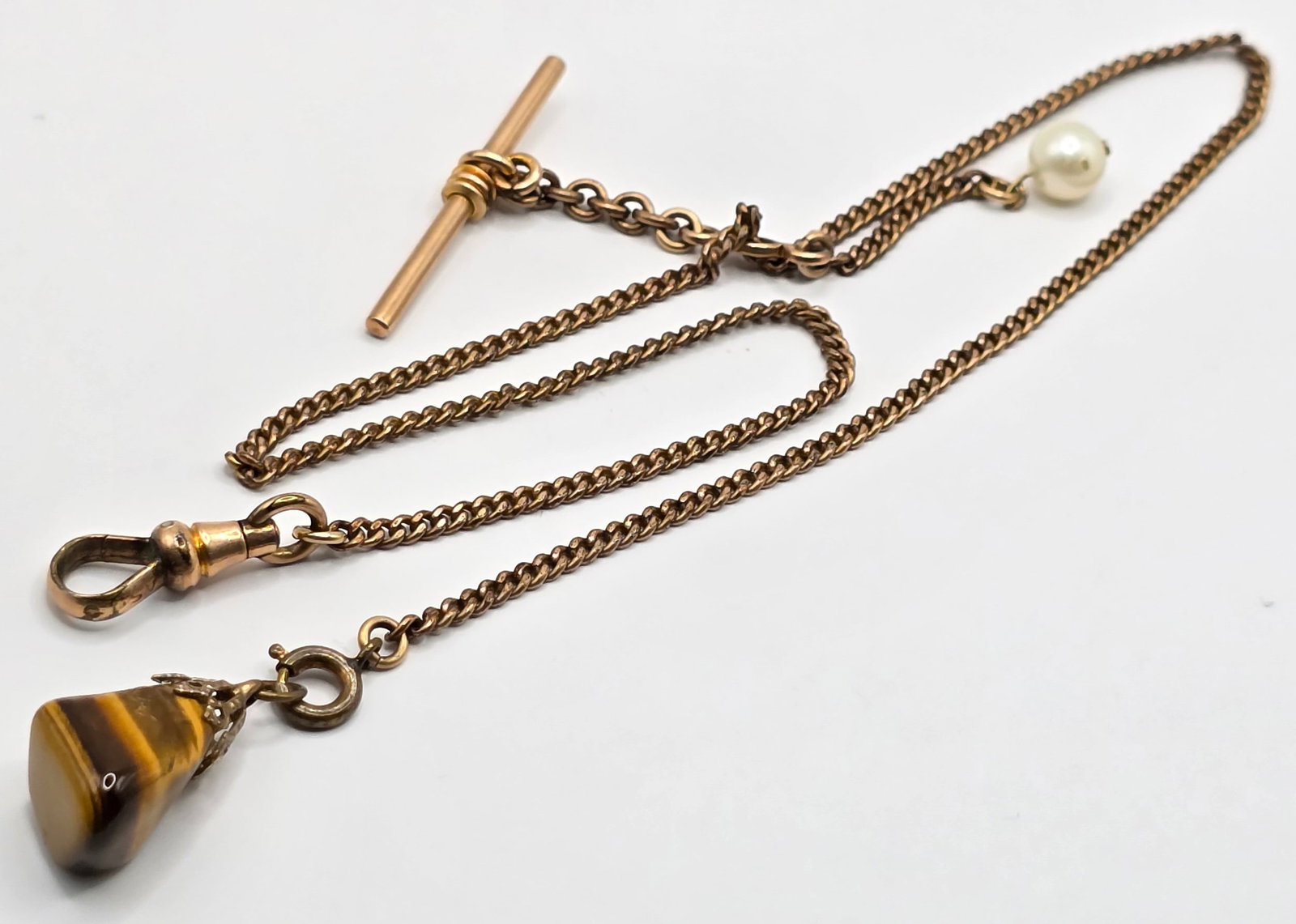 Antique Yellow Gold Filled Watch Chain With Tiger Eye Charm: Antique Yellow Gold Filled Watch Chain With Tiger Eye Charm. Chain is in nice condition and measures 15-1/2" long.