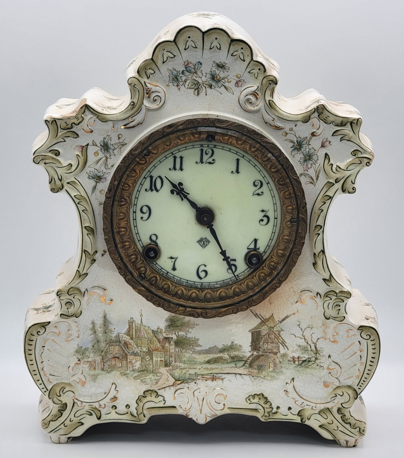 Antique Ansonia Mantle Clock With A Royal Bonn Porcelain Case: Antique Ansonia Mantle Clock With A Royal Bonn Porcelain Case. The clock displays well, but has some chips and cracks and is not tested, missing the key. Measures 12" tall x 9-3/4" across x 4-1/2" dee