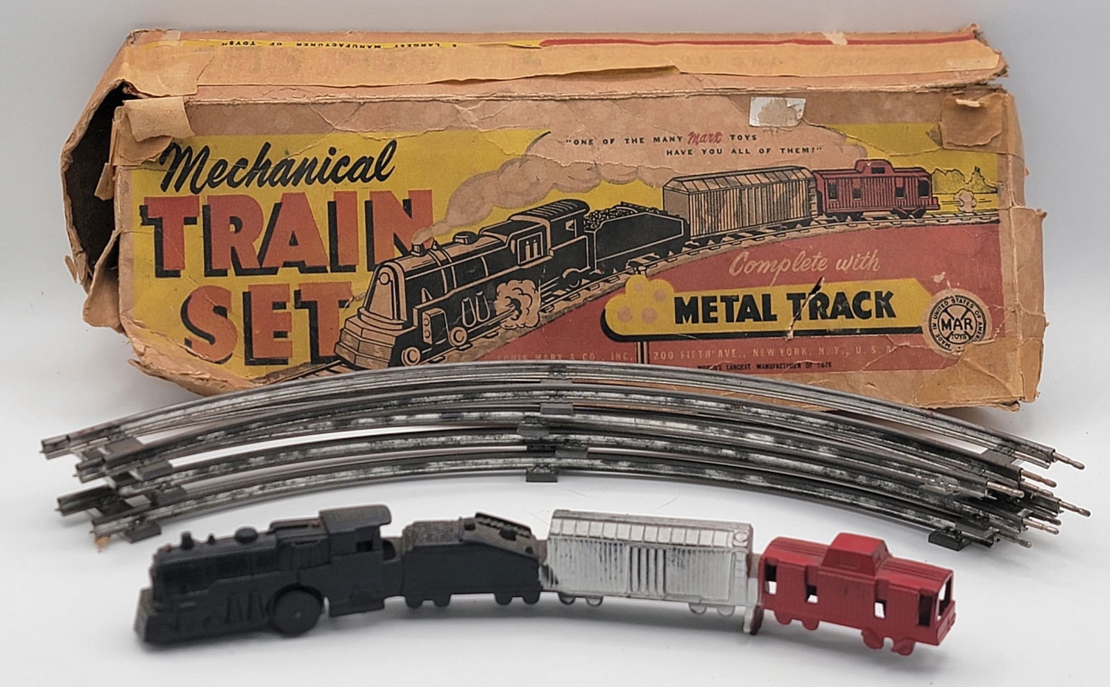 Vintage Marx Wind-Up Mechanical Train Set In Box: Vintage Marx Wind-Up Mechanical Train Set In Box. The plastic one piece train includes a locomotive, coal tender, box car, and caboose with 4 metal track sections. The set is in good working condition