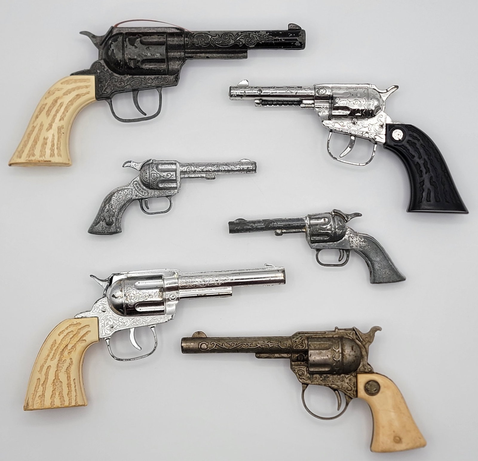 Lot Of Six Vintage Revolver Cap Guns: Lot Of Six Vintage Revolver Cap Guns. Lot includes Buckeroo, Pony Boy, Smoky, and more. Mixed conditions and the sizes range from 5-1/2" to 9-1/2" across.