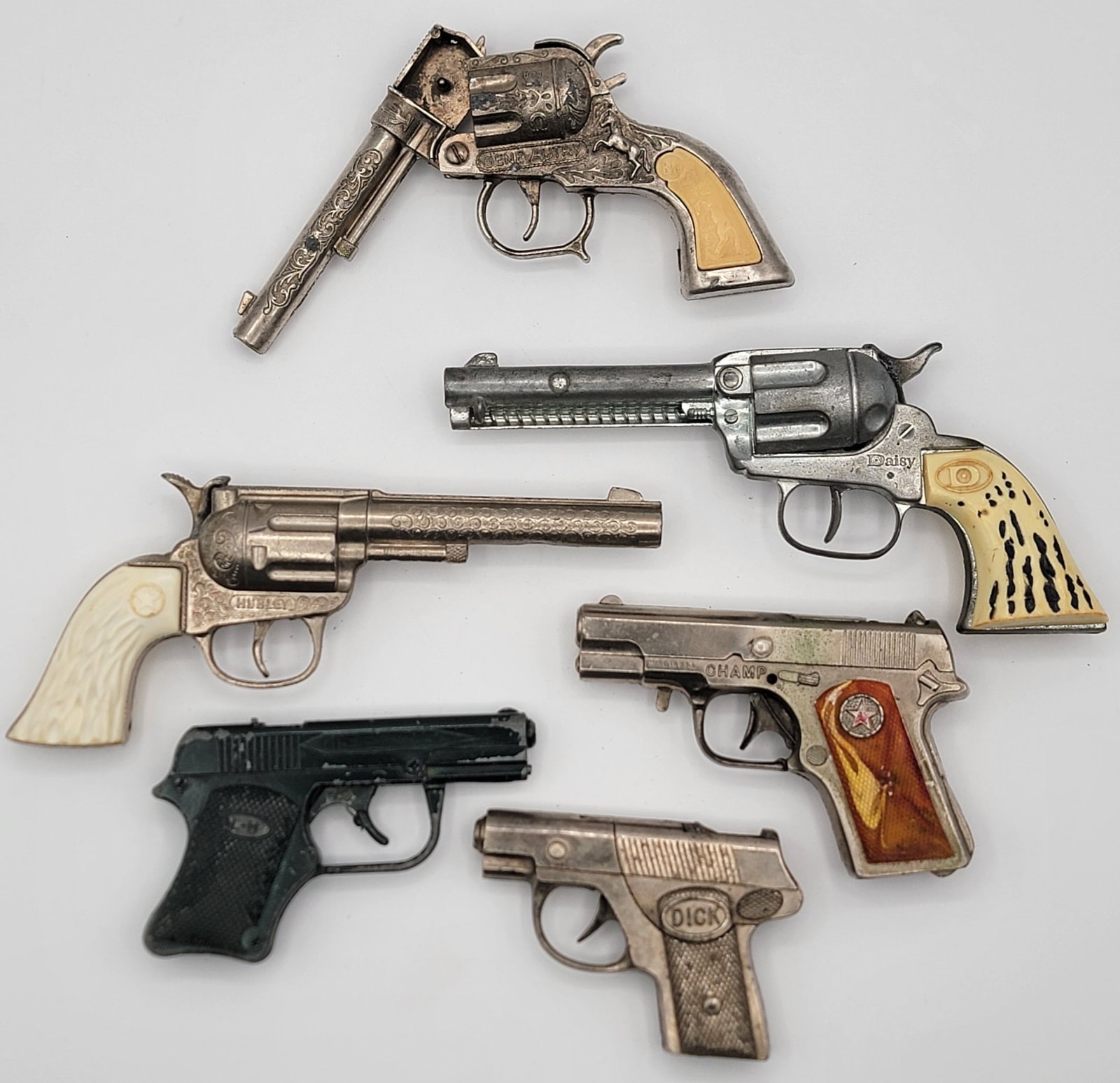 Lot Of Six Vintage Revolver & Pistol Cap Guns: Lot Of Six Vintage Revolver & Pistol Cap Guns. Lot includes Dick, Champ, Daisy, Rodeo, and more. Mixed conditions and the sizes range from 4-1/4" to 8-1/4" across.