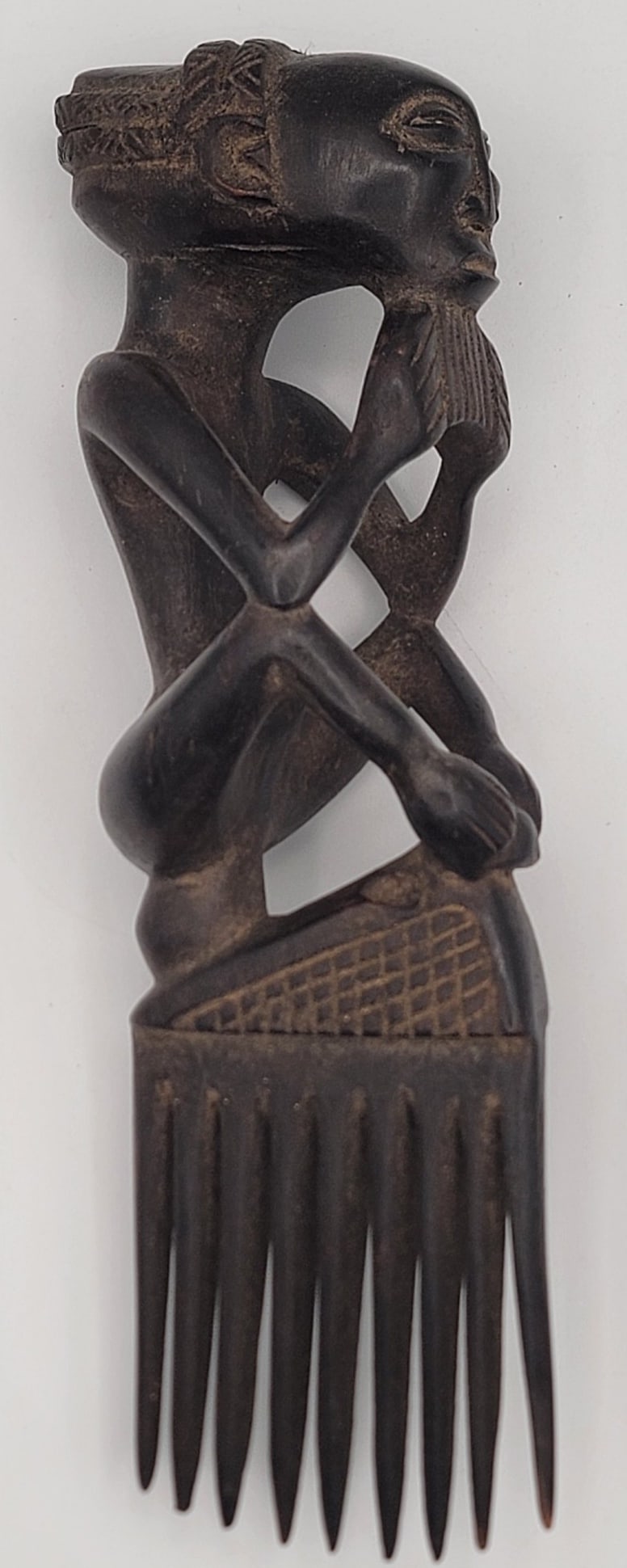 Vintage African Baule Ivory Coast Hand Carved Wood Seated Ancestor Comb: Vintage African Baule Ivory Coast Hand Carved Wood Seated Ancestor Comb. The comb is in nice condition with great workmanship. Measures approximately 9-1/2" tall x 3" wide.