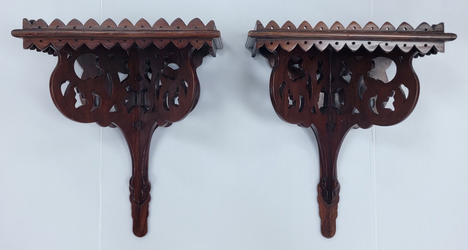 Pair Of Decorative Indonesian Mahogany Wall Shelves: Pair Of Decorative Indonesian Mahogany Wall Shelves. The shelves have nice detail and are in nice condition. The measure 18" tall x 14-1/2" across x 9" deep.