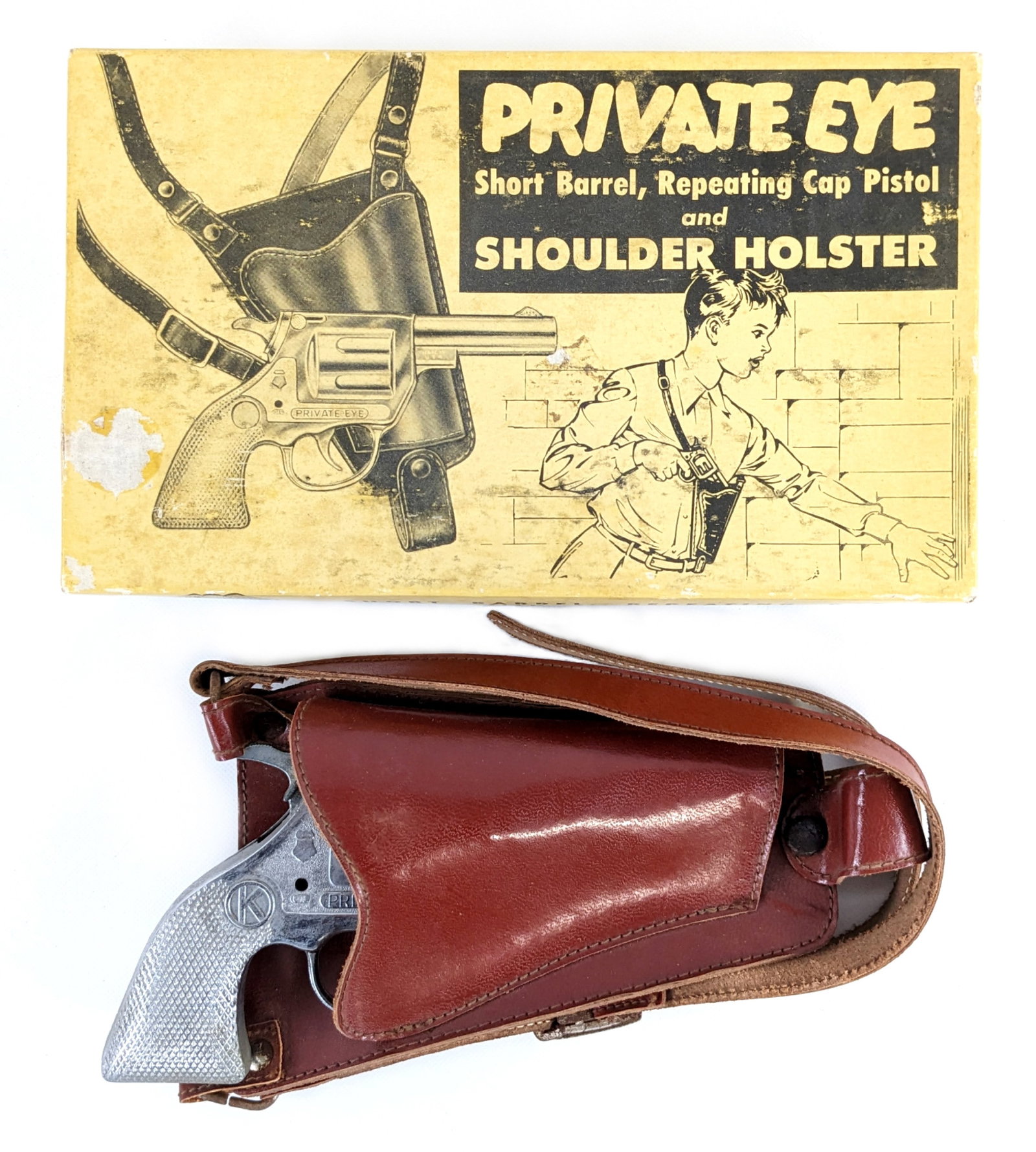 F&G Products Kilgore Private Eye Cap Gun w/ Shoulder Holster In Box: F&G Products Kilgore Private Eye short barrel repeating cap pistol and shoulder holster in the original box. The cap gun has some very minor oxidation, but functions properly. The box has some stainin
