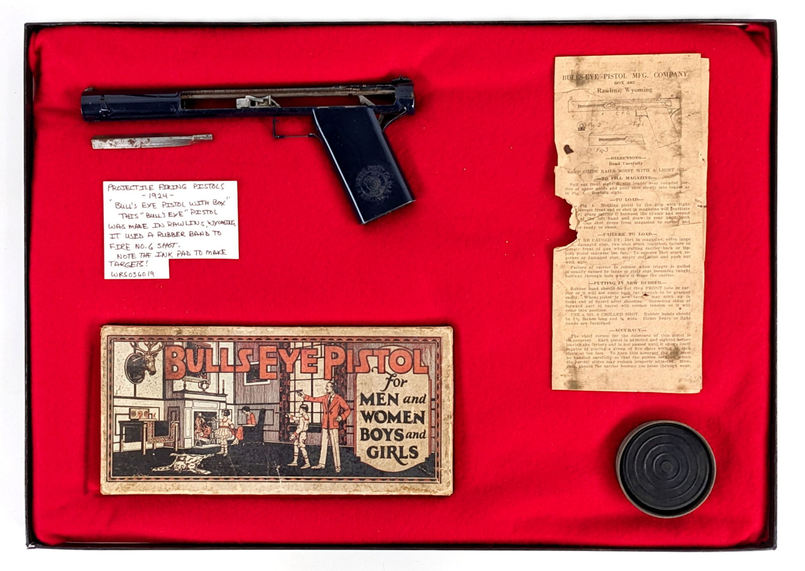 Early Bulls Eye Pistol w/ Original Box: Early Bulls Eye rubber band pistol with original box and instruction sheets. The gun has some paint crazing and wear from age. The box has staining and the instruction sheet has some tearing and stain