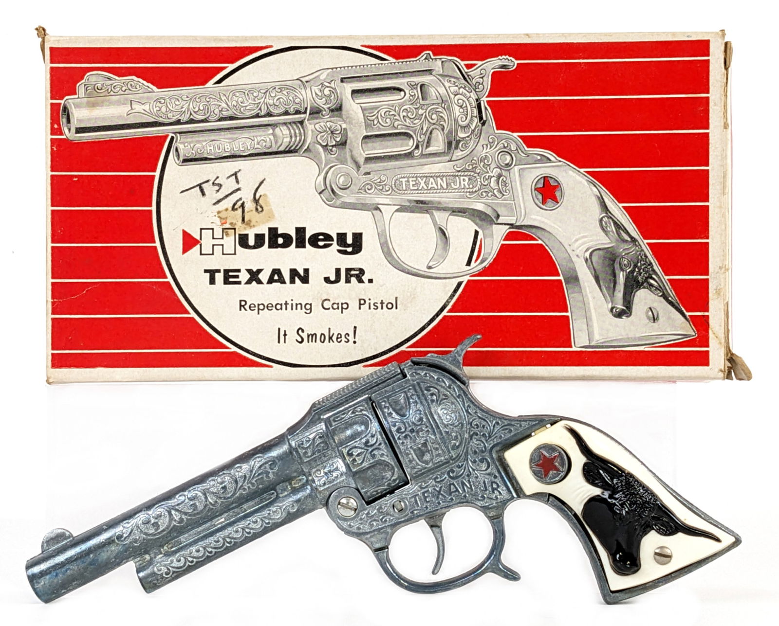 Hubley Texan Jr. Cap Pistol Gun w/ Box: Hubley Texan Jr. cap pistol gun in original box. The grips have some warping. The gun works as it should. The box has some minor staining, one main flap is taped, and writing on the box.