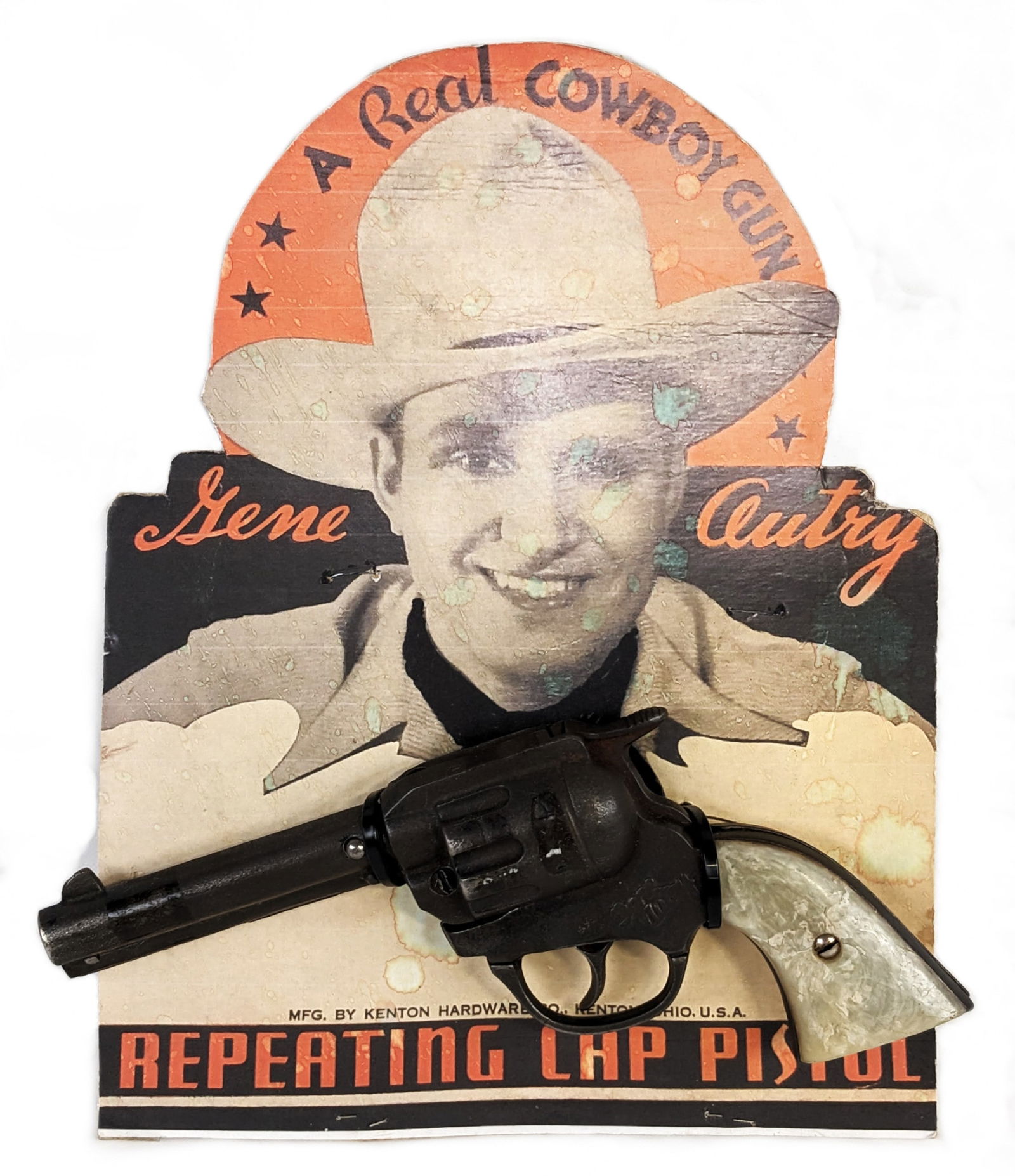 Kenton Gene Autry Cap Gun Pistol w/ Repro Display: Kenton cast iron Gene Autry cap gun pistol with reproduction display stand. The gun works, but the trigger sometimes sticks. The display has fading and staining. The gun measures 8" long.